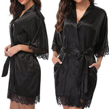 Black satin robe with lace trim worn by a model on a white background